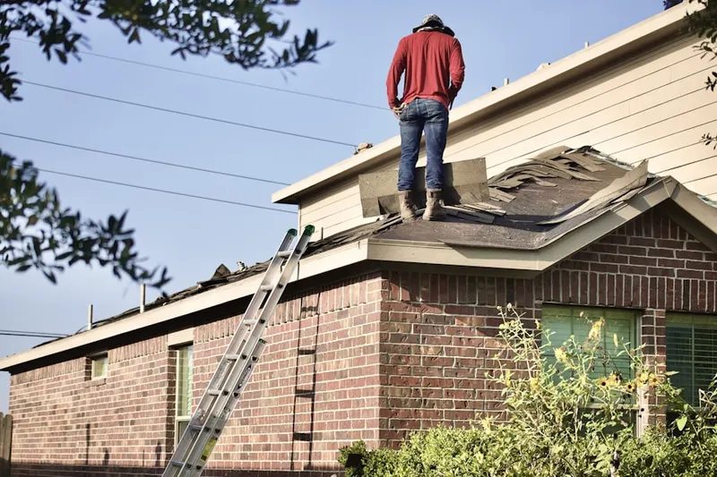 Professional roofer working on a residential roof in Laura's Place